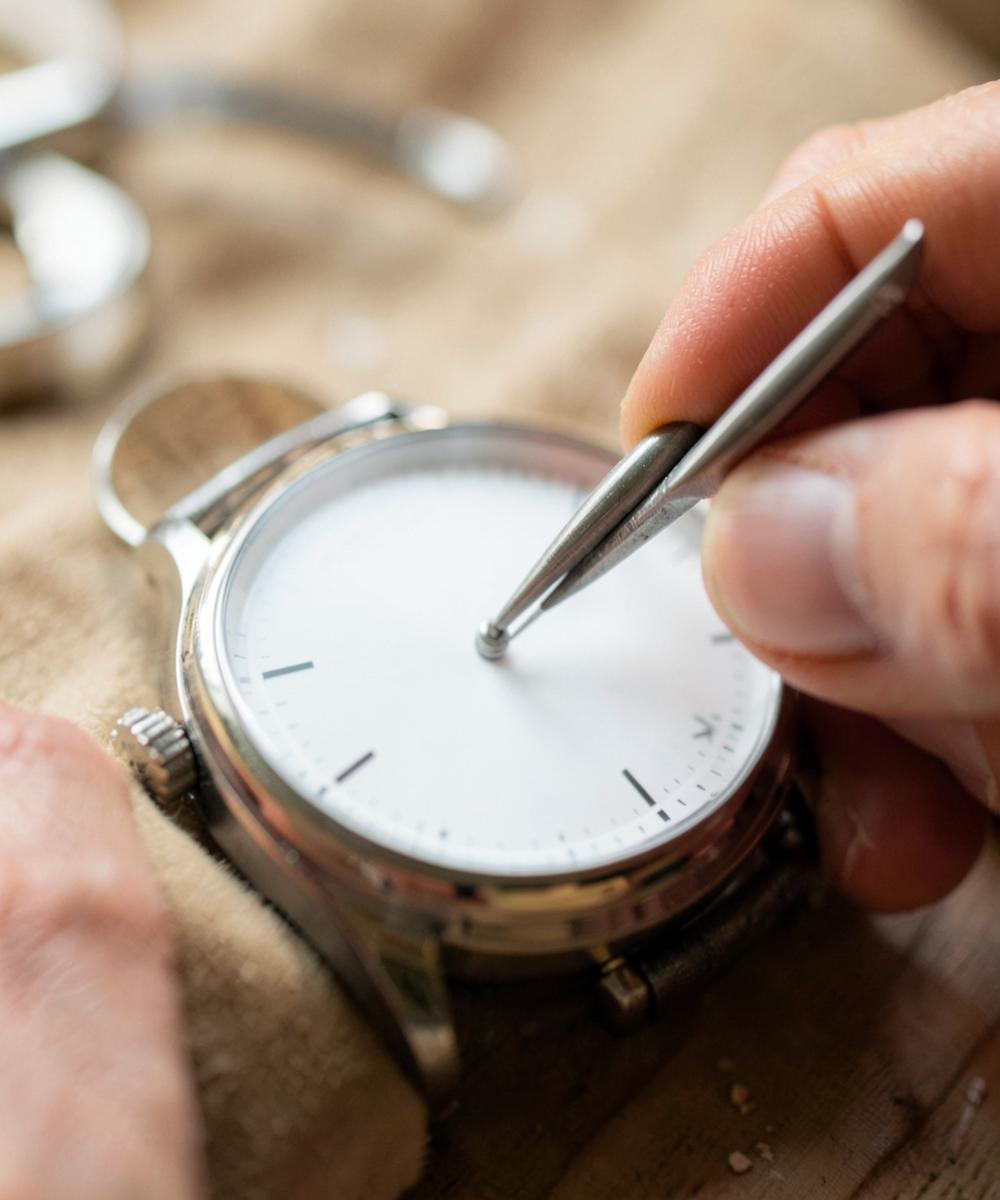 Hands being fitted to a blank watch dial